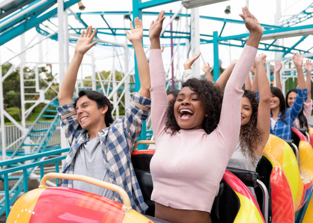 A rollercoaster reaching its peak, with excited riders raising their hands in triumph, A rollercoaster reaching its peak, with excited riders raising their hands in triumph,